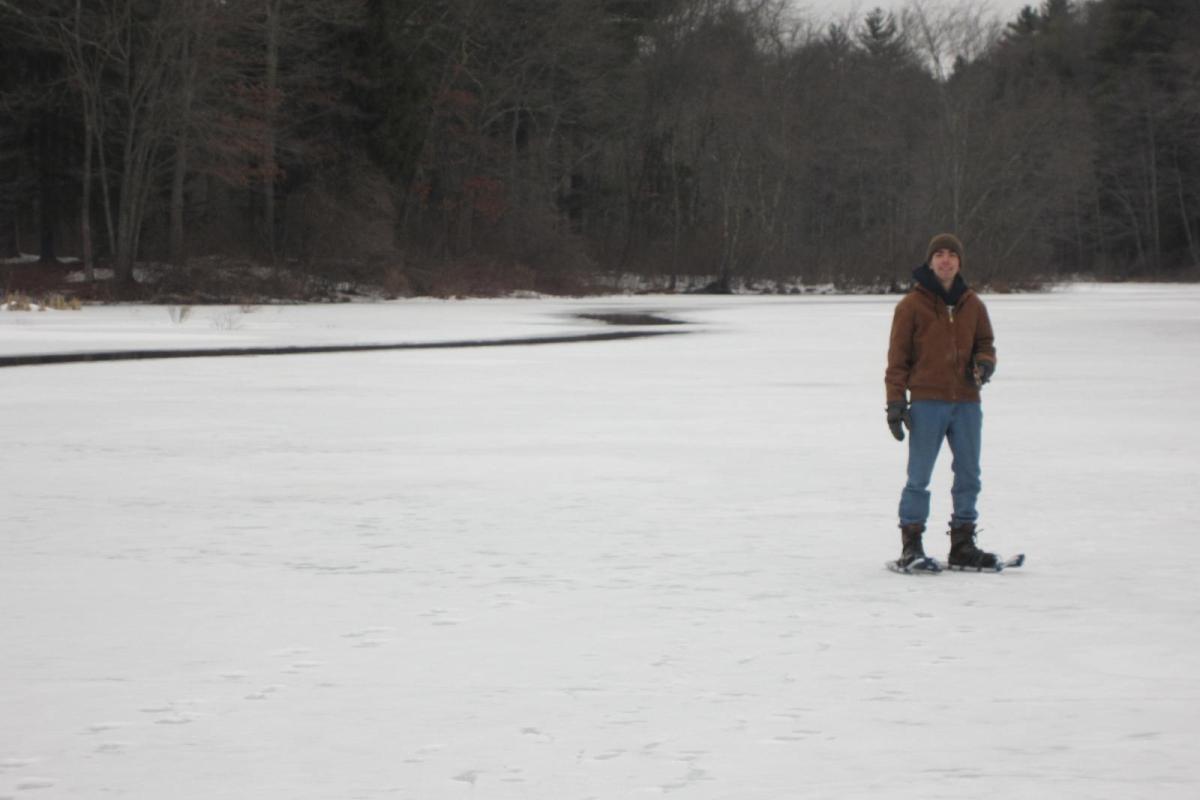 Steve Riggott on his way to clear trails, walking down the frozen Neponset River